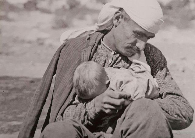 Η σπάνια φωτογραφία με ένα πατέρα να κρατά το μωρό του αγκαλιά. Το πορτρέτο του πρόσφυγα από τη Μικρά Ασία που ανέτρεψε τα κοινωνικά πρότυπα και απεικόνισε τη δυστυχία της προσφυγιάς... - Φωτογραφία 1