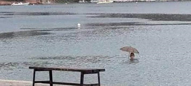 Δεν υπάρχει: Εβρεχε και μπήκε στη θάλασσα για μπάνιο με… ομπρέλα! (φωτο) - Φωτογραφία 1