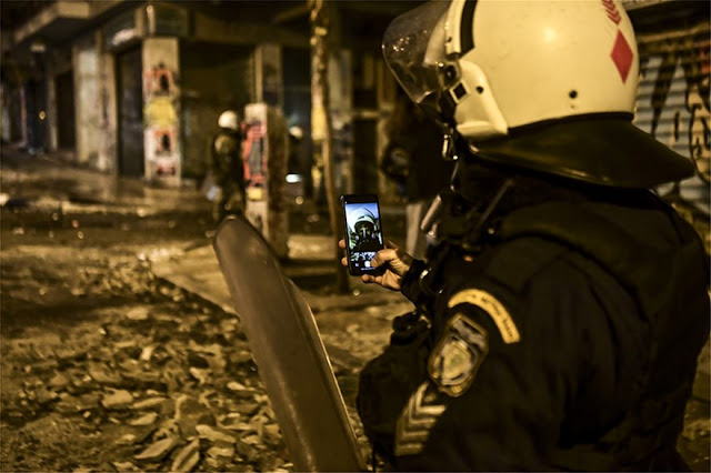 Απίστευτη φωτογραφία από το Γαλλικό Πρακτορείο Ειδήσεων: Η selfie αστυνομικού των ΜΑΤ στα αποκαΐδια των επεισοδίων! - Φωτογραφία 1