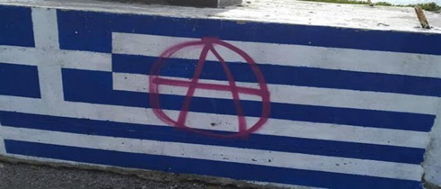Εικόνες ντροπής: Έβαψαν με σπρέι στην ελληνική σημαία το σύμβολο της αναρχίας - Φωτογραφία 1