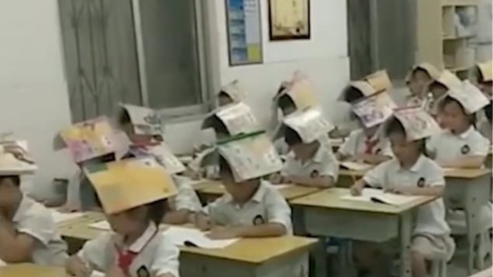 Δάσκαλος φόρεσε καπέλο τα βιβλία στους μαθητές του για να μην... καμπουριάζουν - Βίντεο - Φωτογραφία 1