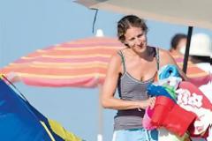 Η Σάρα Τζέσικα Πάρκερ με κουβαδάκια στα χέρια και κλάμερ στα μαλλιά στην Aίγινα