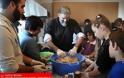 Ιερέας μαθαίνει σε παιδιά πως να φτιάχνουν μελομακάρονα