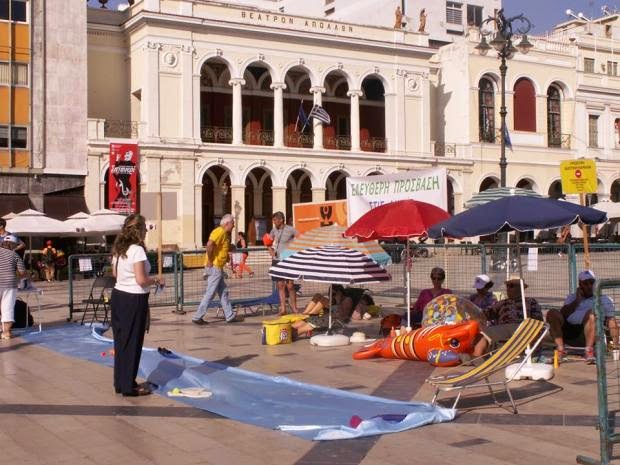 Πάτρα: Φόρεσαν μπρατσάκια και μαγιό και έκαναν ηλιοθεραπεία στην... πλατεία Γεωργίου! - Η πρωτότυπη διαμαρτυρία για την εκχώρηση αιγιαλών - Φωτογραφία 2