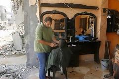 Εικόνες που σοκάρουν στη Γάζα - Κάνουν ουρές για ένα κούρεμα μέσα στα ερείπια [photos]