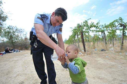 ΣΥΓΚΛΟΝΙΣΤΙΚΗ ΕΙΚΟΝΑ: Αστυνομικός ξεδιψά παιδάκι στα σύνορα Ελλάδας - Σκοπίων - Φωτογραφία 2