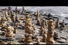 Παραλία γεμάτη με πύργους από πέτρες