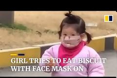 Γλυκύτατο κοριτσάκι προσπαθεί να φάει μπισκότο φορώντας... ιατρική μάσκα (video)