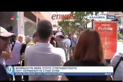 Υπάλληλοι τράπεζας μοιράζουν νερό και χυμούς στους συνταξιούχους